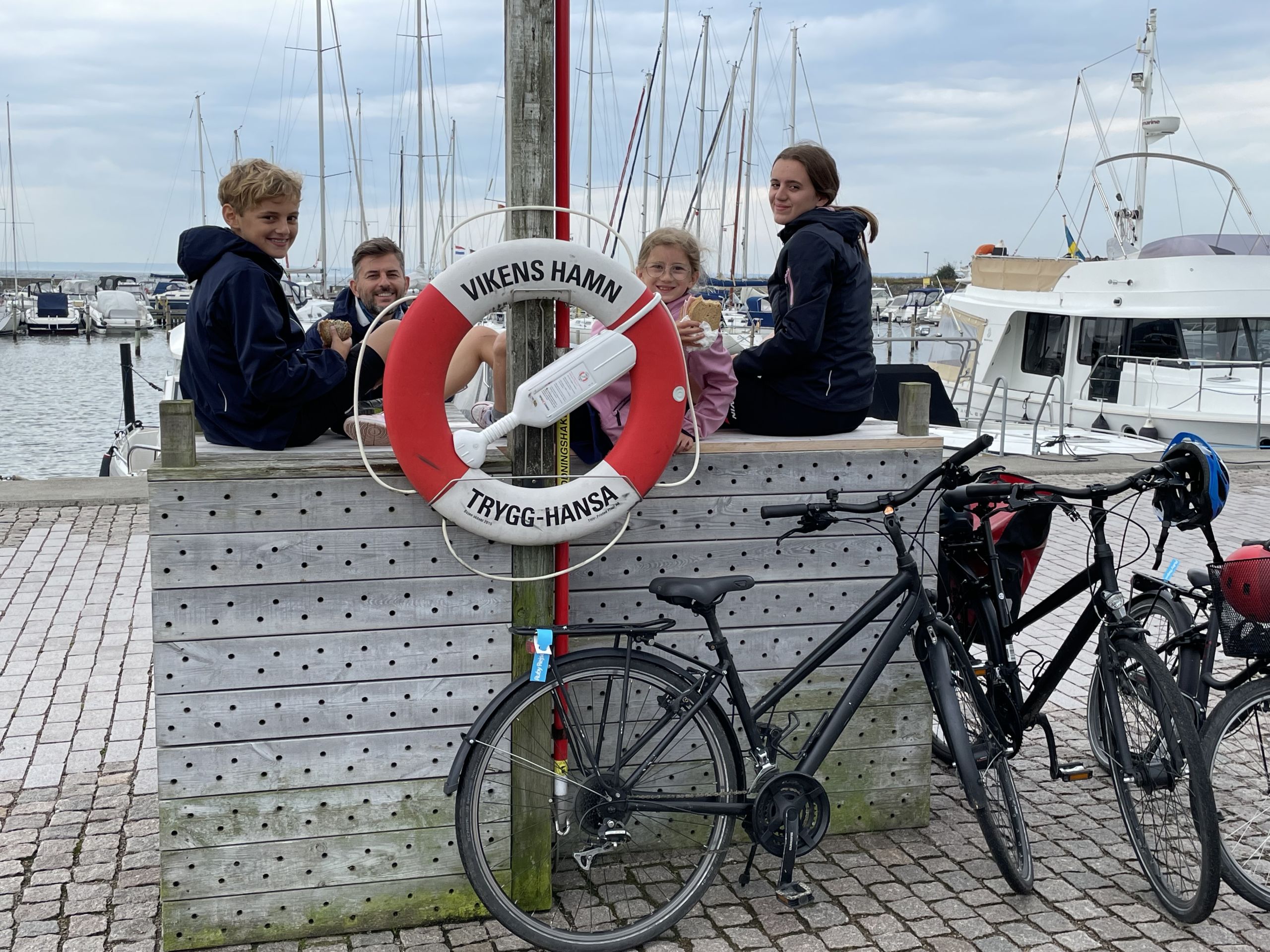 Famiglia con bambini in pausa vicino al molo con barche ormeggiate, Danimarca